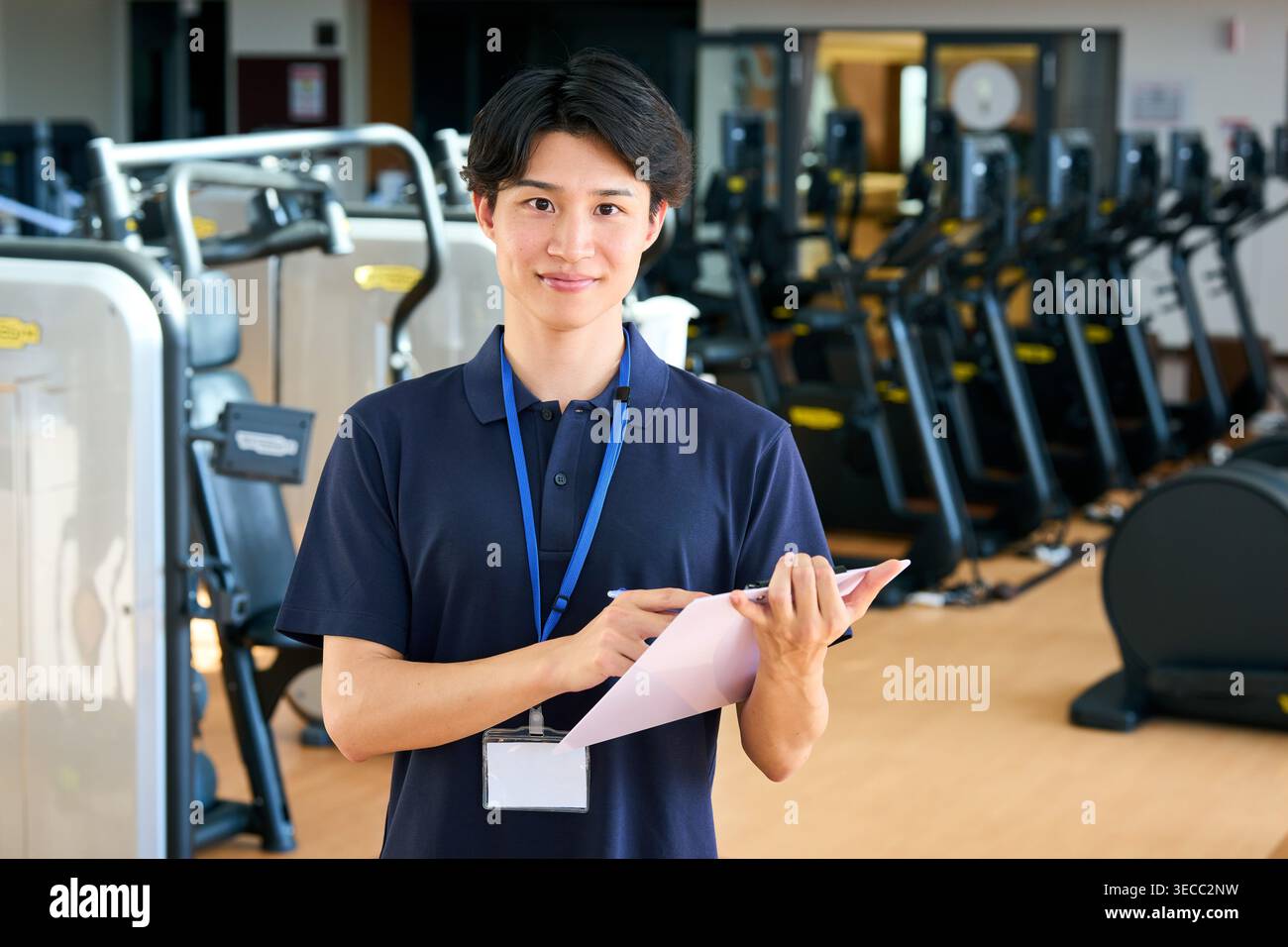 Portrait d'un jeune entraîneur japonais souriant regardant la caméra dans un gymnase Banque D'Images