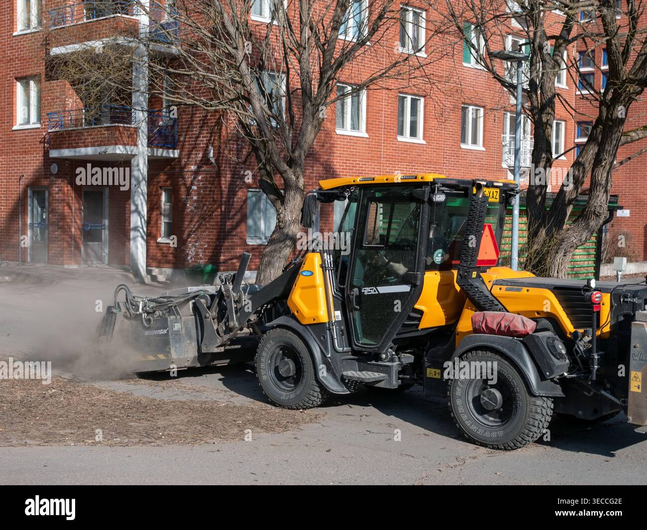 Balayeuse de rue dans les sentiers de nettoyage de parc au printemps, Oulu Finlande Banque D'Images