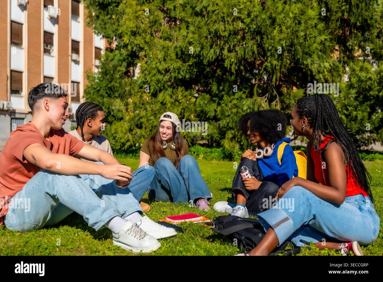 Étudiants divers se relaxant, partageant et étudiant sur le campus universitaire Banque D'Images