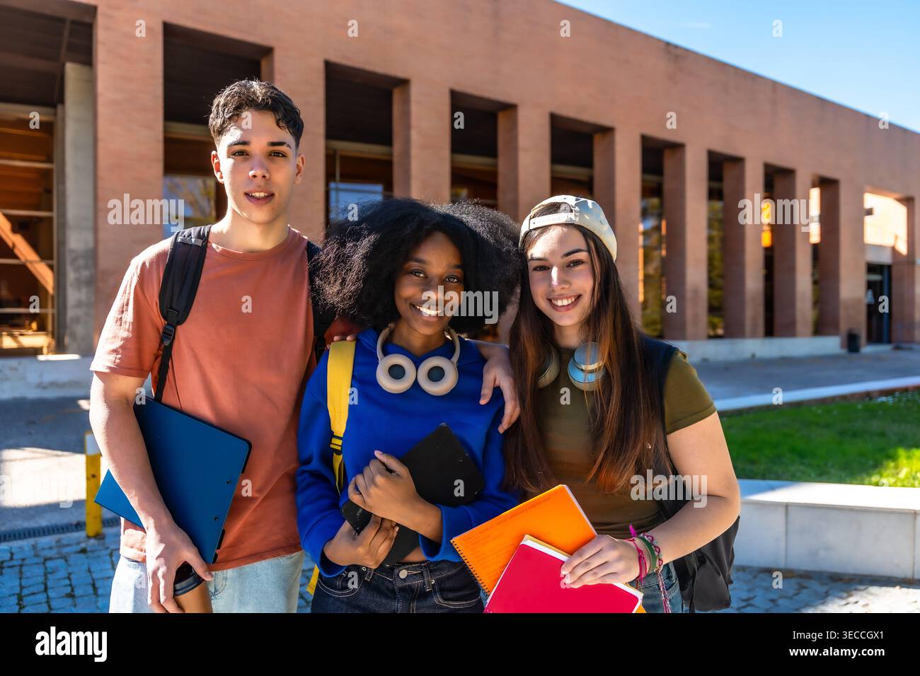 Amis étudiants divers souriant sur le campus universitaire Banque D'Images