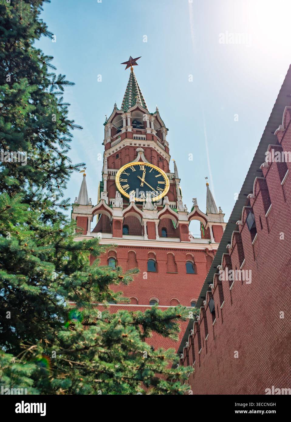 Moscou, Russie - 23 juin 2021 : Tour Spasskaya historique avec son horloge emblématique et son étoile rouge, encadrée par des arbres verts, sous un ciel bleu vif Banque D'Images