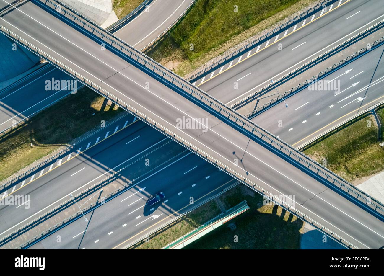 Système moderne d'échange routier avec plusieurs voies et véhicules en mouvement vus d'une vue aérienne pendant la journée ensoleillée Banque D'Images