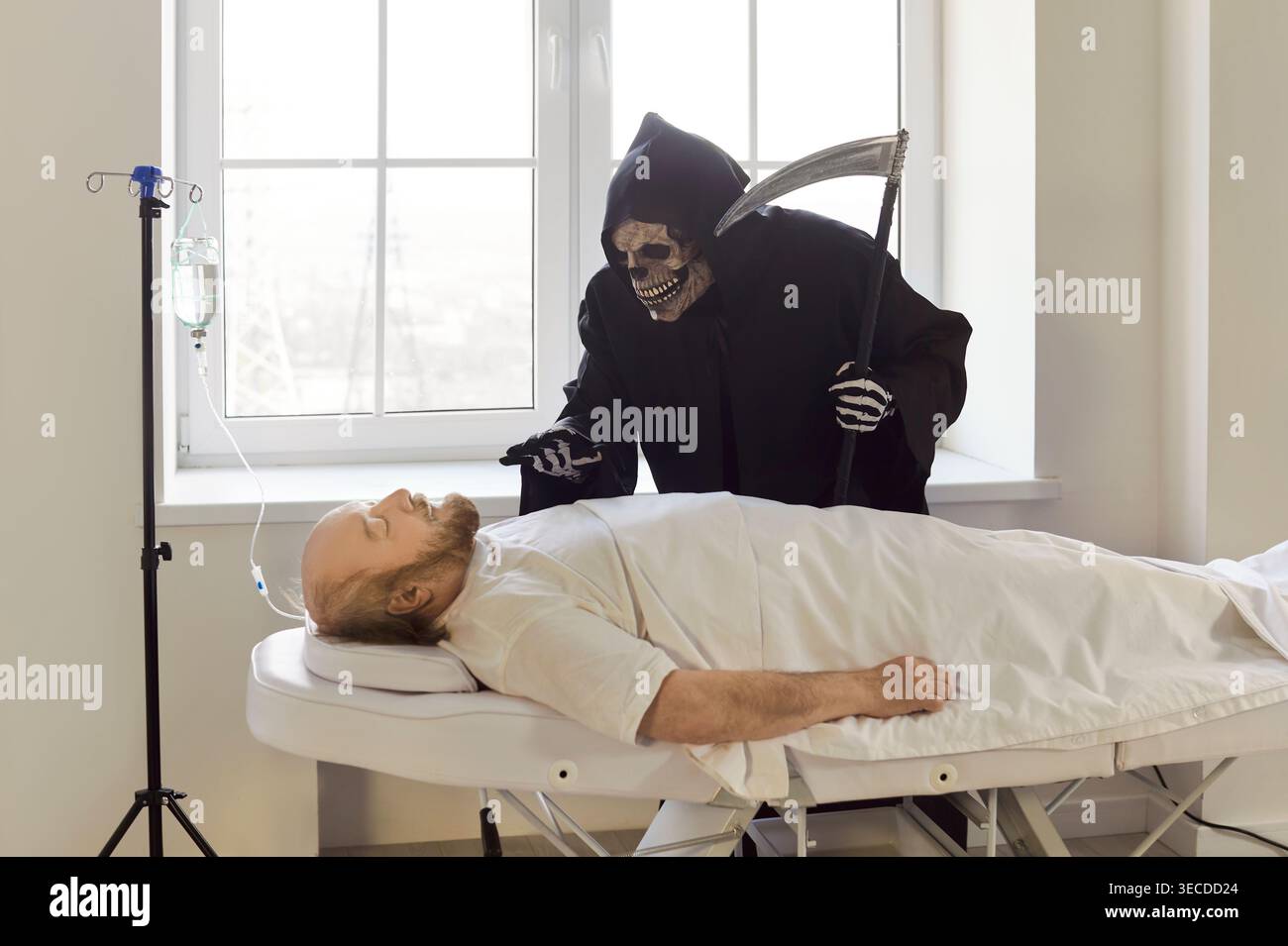 Homme âgé inconscient avec perfusion intraveineuse allongé sur le canapé de l'hôpital alors qu'une faucheuse sombre se tenait à proximité. Banque D'Images