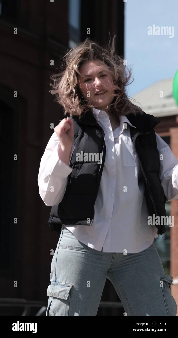 Figure féminine capturée en mouvement avec une expression joyeuse et une lumière naturelle sur son visage. Le moment vivant met en valeur le bonheur, la liberté et l'authenticité Banque D'Images