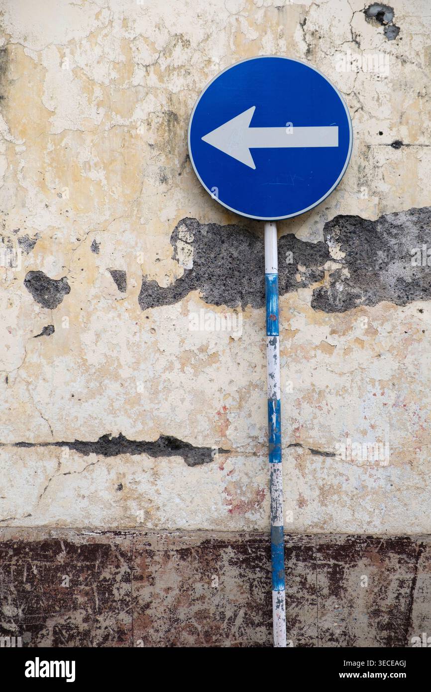 Panneau de système à sens unique à côté d'un mur en décomposition à Funchal Madère Banque D'Images