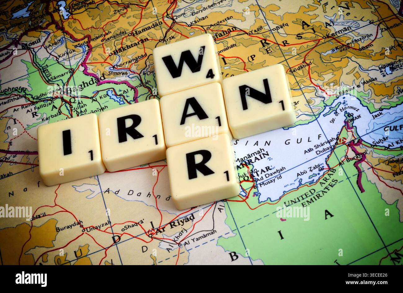 Image de concept de guerre en Iran avec des tuiles de lettres sur la carte du moyen-Orient près du détroit d'Ormuz, mettant en évidence les risques liés au transport maritime dans le Golfe Banque D'Images