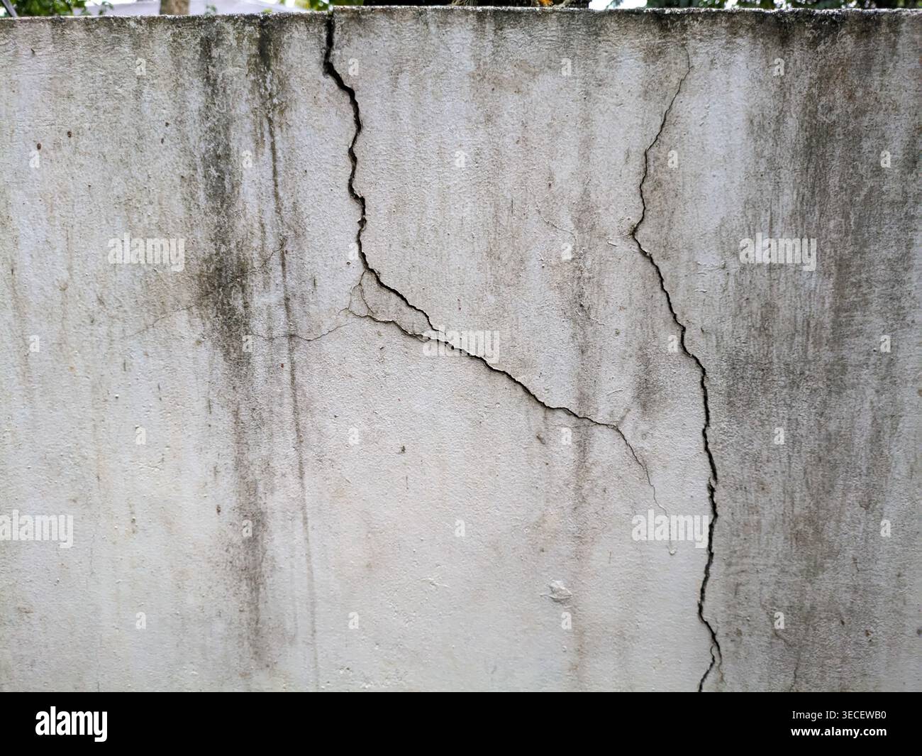 Motif de fissure naturelle sur fond de mur blanc endommagé – surface texturée avec fractures visibles et structure altérée, detai architectural abstrait Banque D'Images