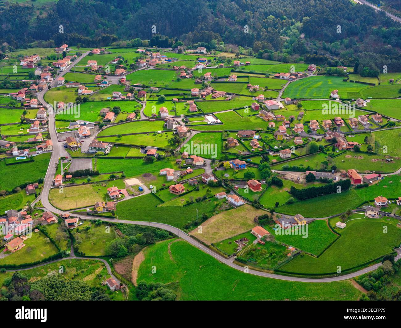 Vue aérienne d'un village rural avec des maisons dispersées parmi les champs verdoyants et les routes sinueuses à Cudillero, Asturies, Espagne. Banque D'Images