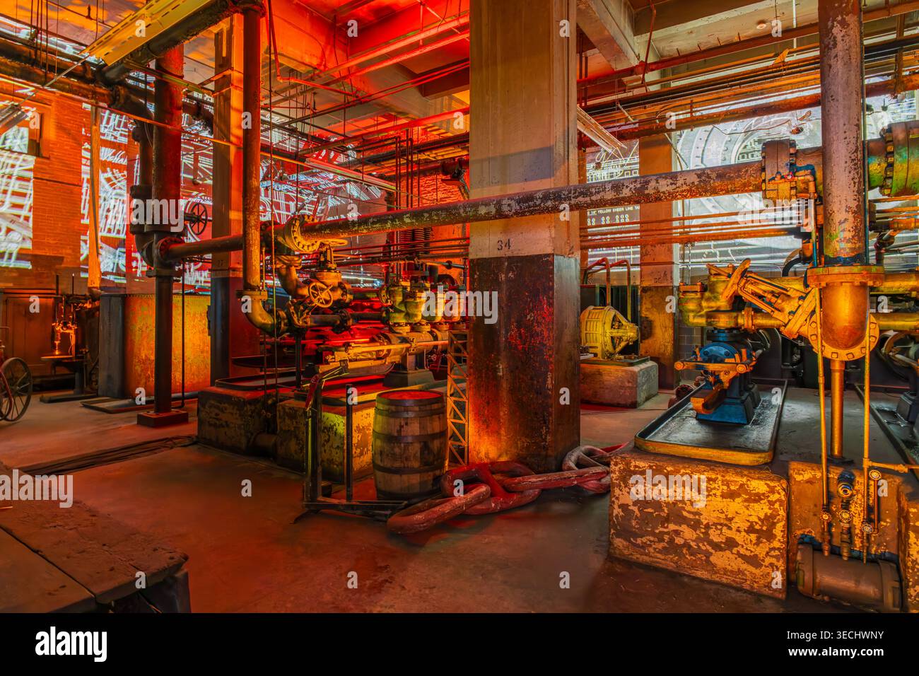 Kansas, États-Unis, 18 janvier 2026 - des tuyaux métalliques altérés, des machines lourdes et des barils usés se trouvent au milieu de l'infrastructure complexe d'un éclairage tamisé Banque D'Images