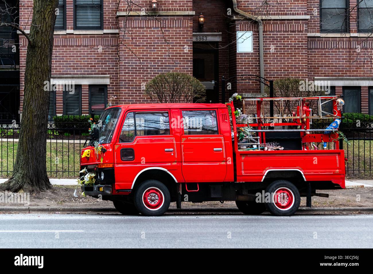 Un petit camion rouge était garé dans l'une des rues de Chicago, en face d'une maison en briques rouges. Banque D'Images