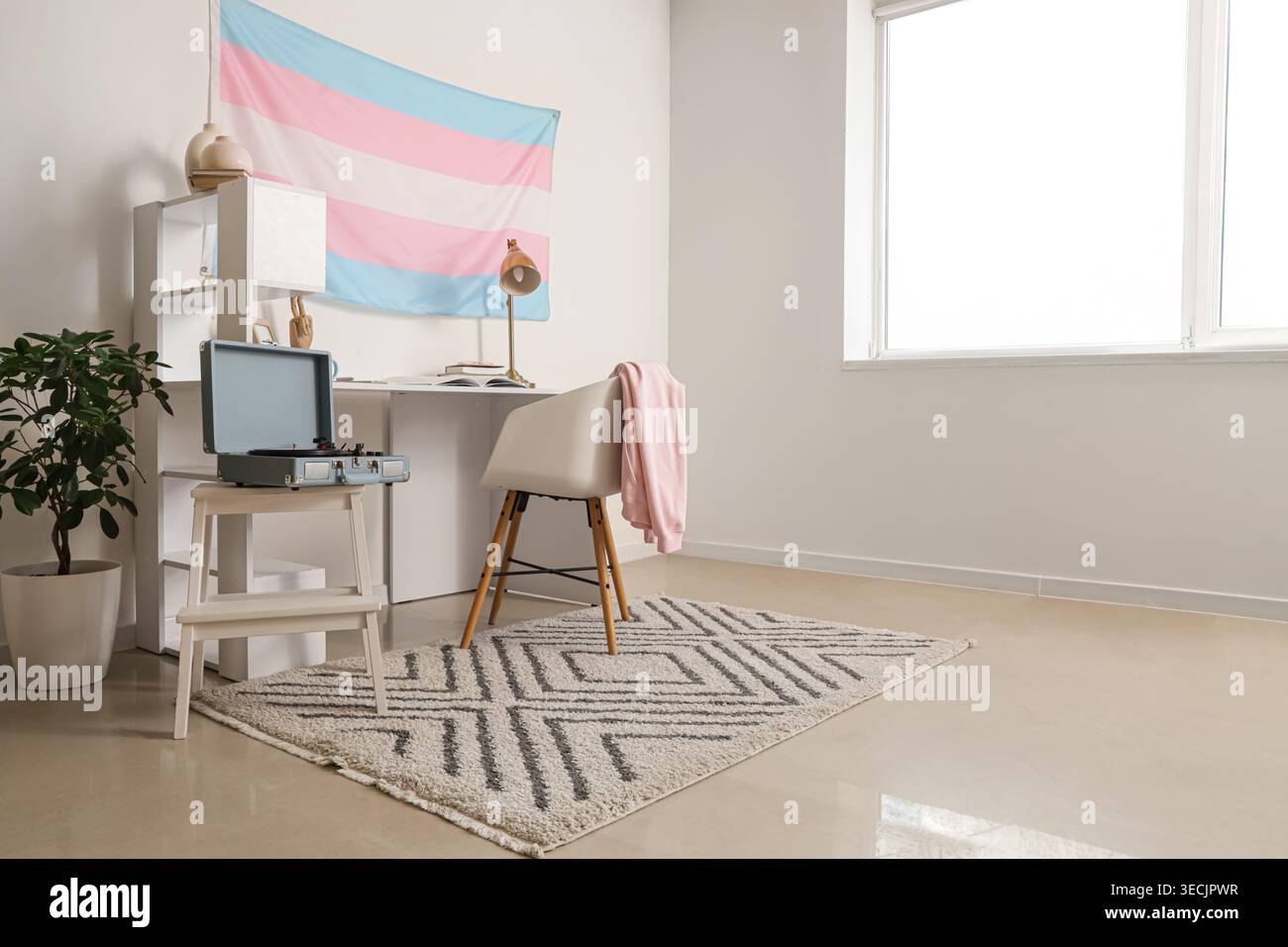 Intérieur de la pièce lumineuse avec lieu de travail et drapeau transgenre Banque D'Images