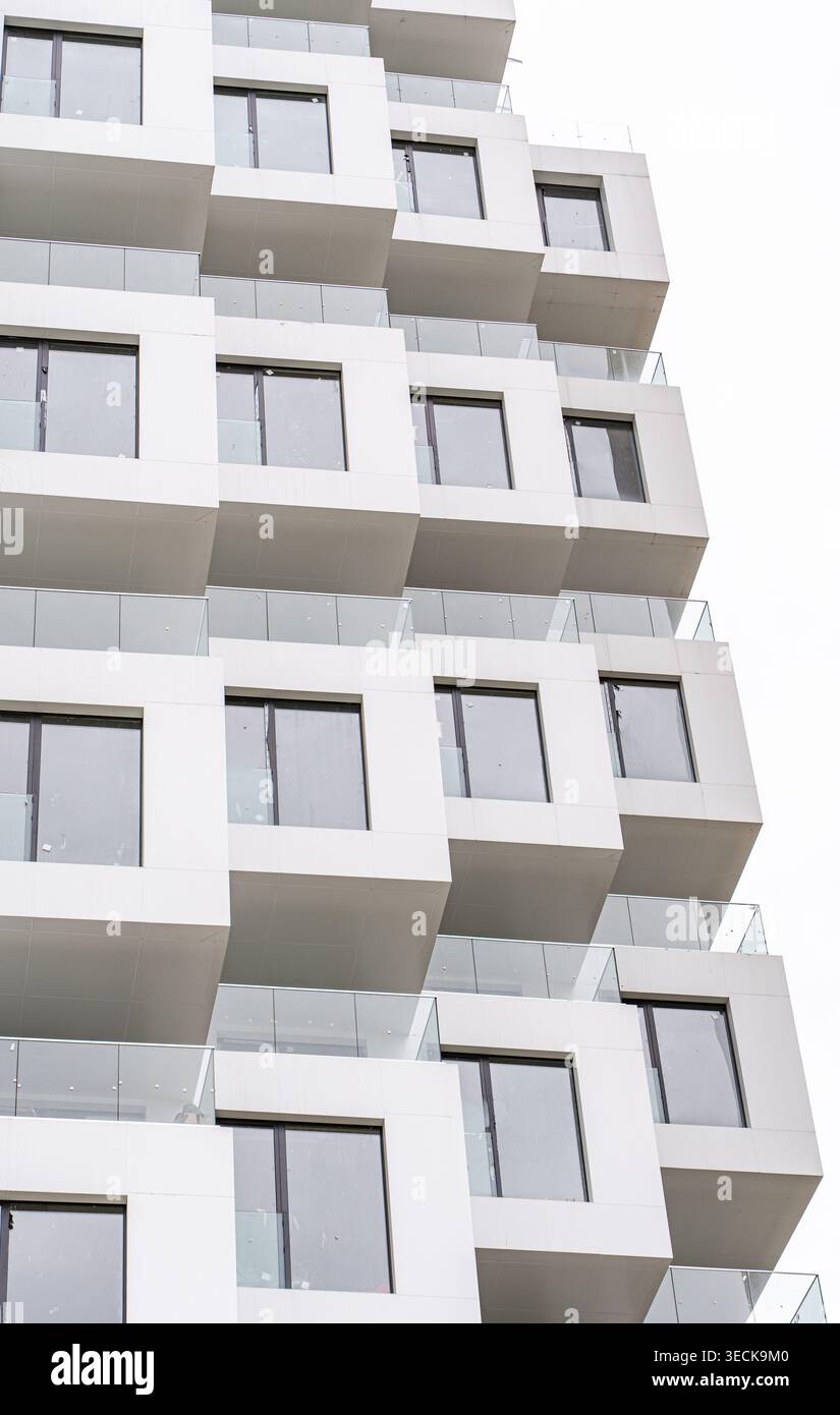 Gros plan d'une façade d'immeuble moderne avec balcons cubiques empilés, structure en béton, balustrades en verre et cadres métalliques, avec geom propre Banque D'Images