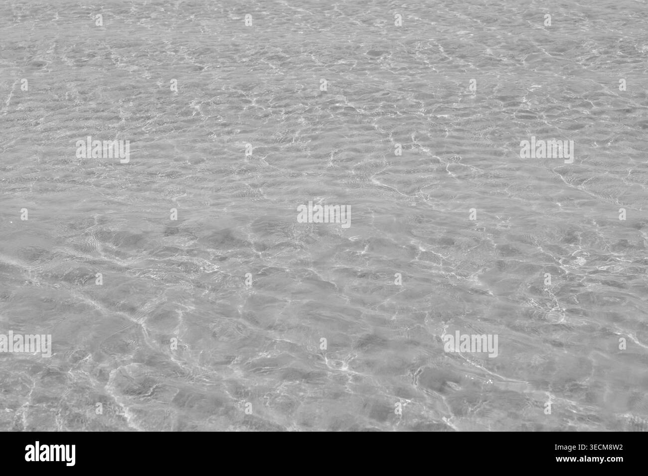 Texture d'ondulations claires de l'eau de l'océan avec réflexion de lumière sur le fond sablonneux véhiculant calme, tranquille, paisible et serein sentiment parfait pour backgroun Banque D'Images