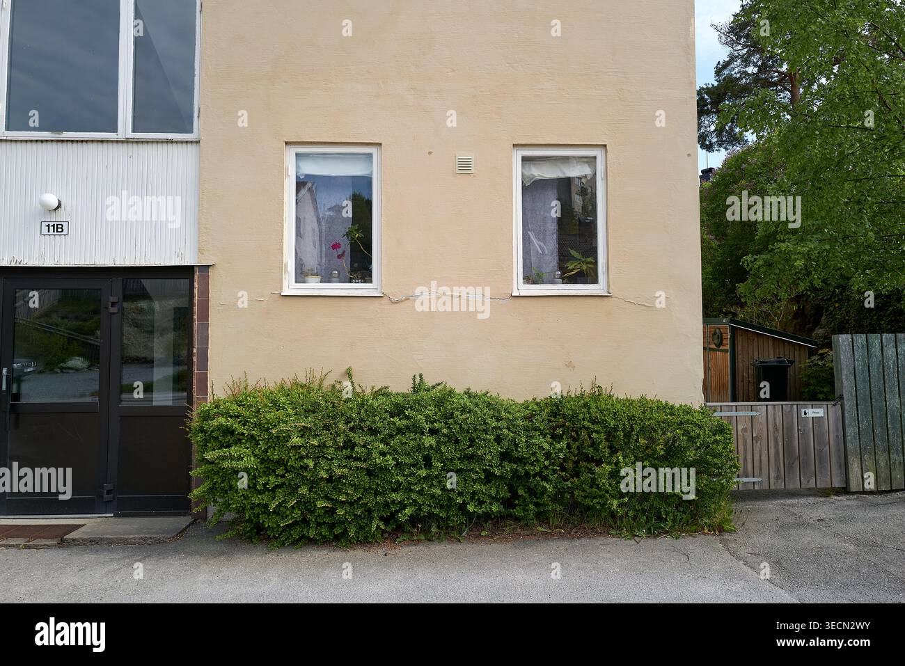 Façade de bâtiment simple et sans ornement avec deux fenêtres avec rideaux couverts pour l'intimité. Nynashamn, comté de Stockholm, Suède, 25 mai 2025 Banque D'Images