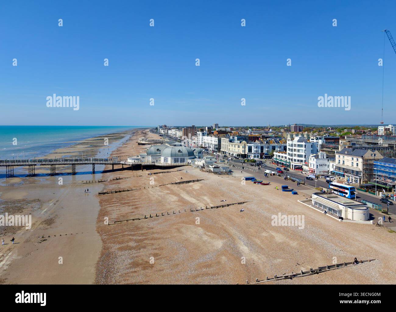 Antenne à faible angle du rivage de la côte sud britannique montrant une plage de galets dans la ville balnéaire de Worthing, West Sussex, Angleterre, Royaume-Uni. Front de mer, ensoleillé. Banque D'Images