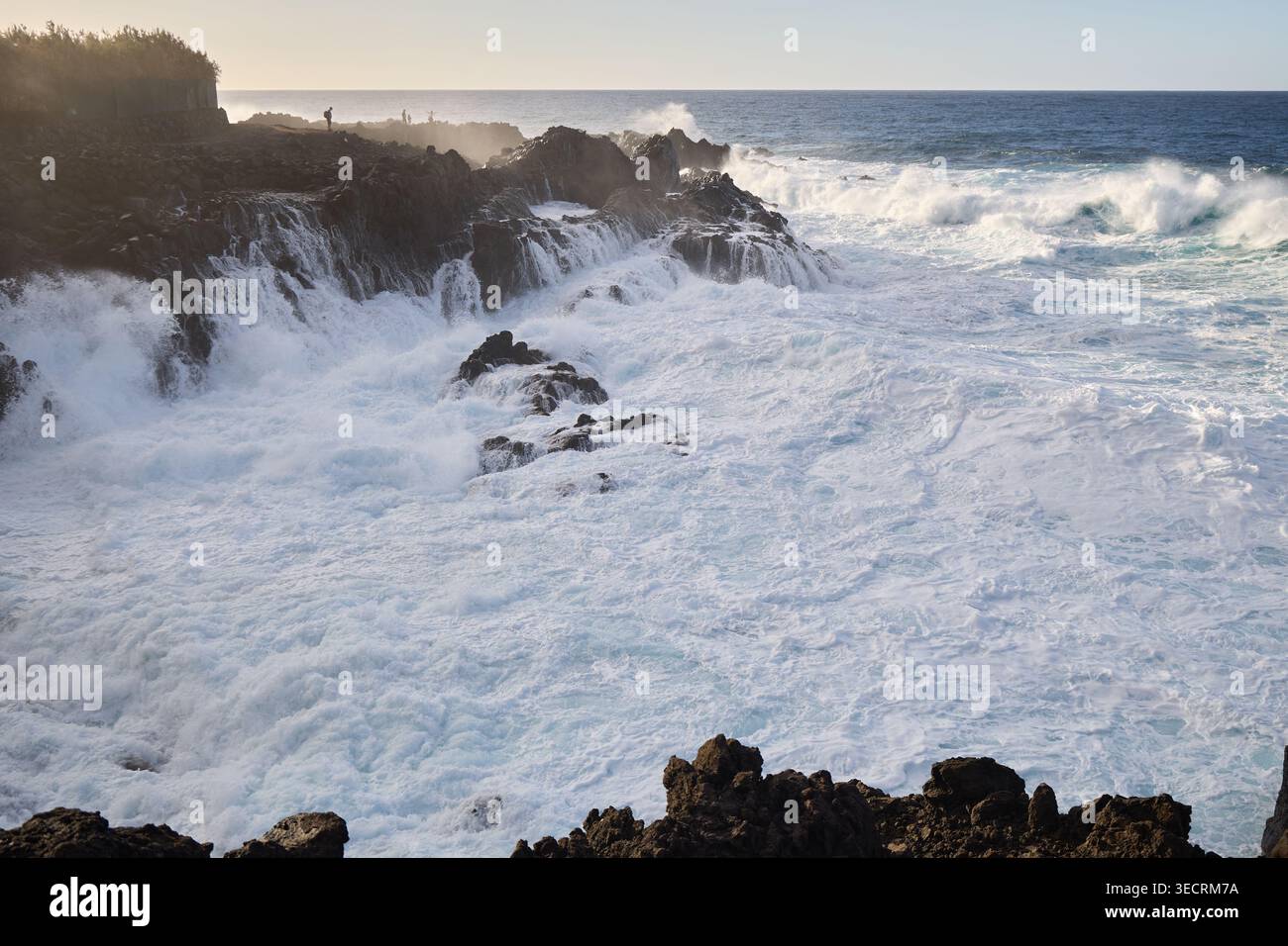 Puissantes vagues océaniques s'écrasant sur les rochers côtiers accidentés Banque D'Images