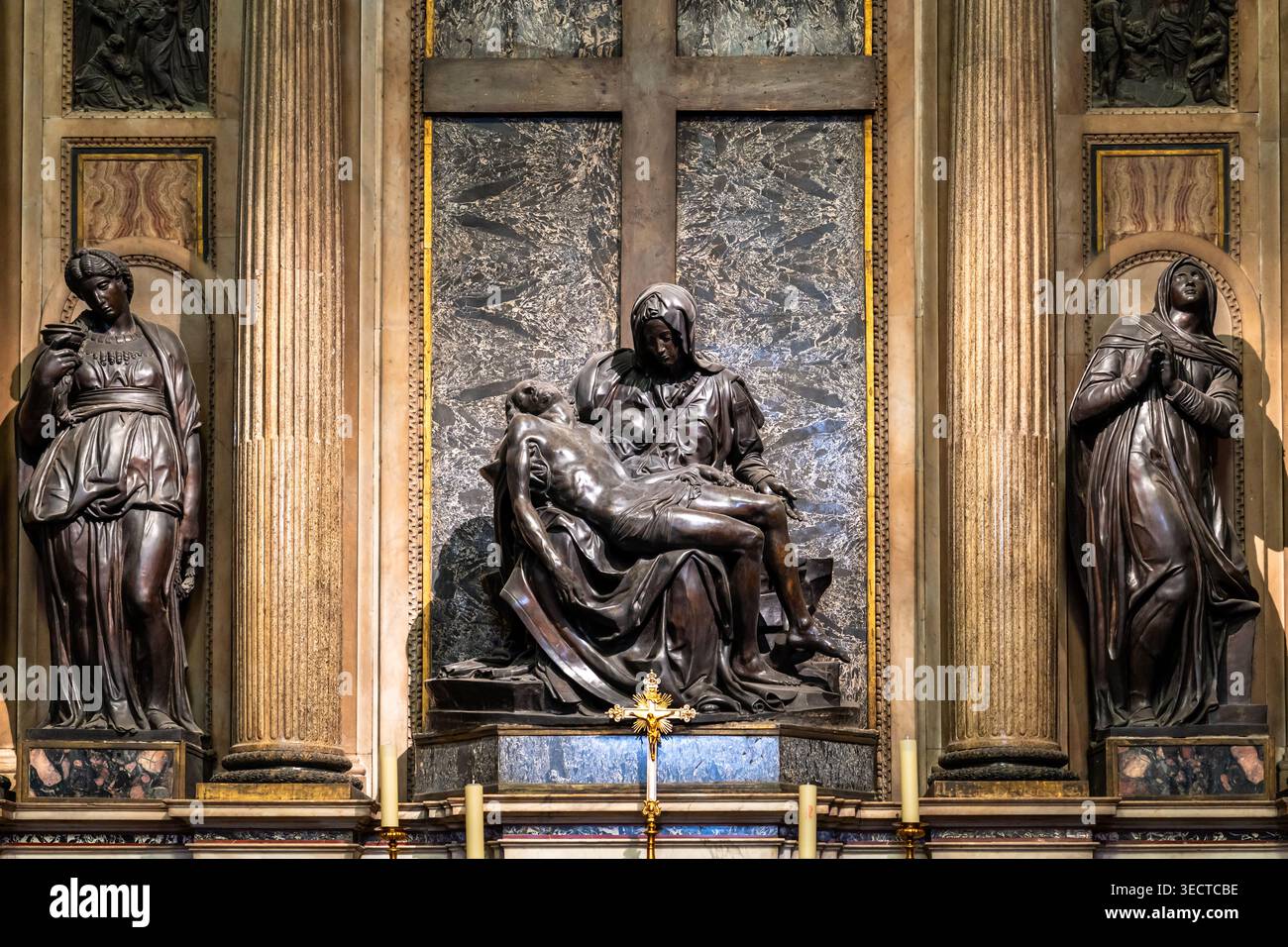 Statues en bronze de femmes et de Vierge Marie portant Jésus mort debout devant le mur décoré de motifs chrétiens à l'intérieur de l'église historique de Rome Banque D'Images