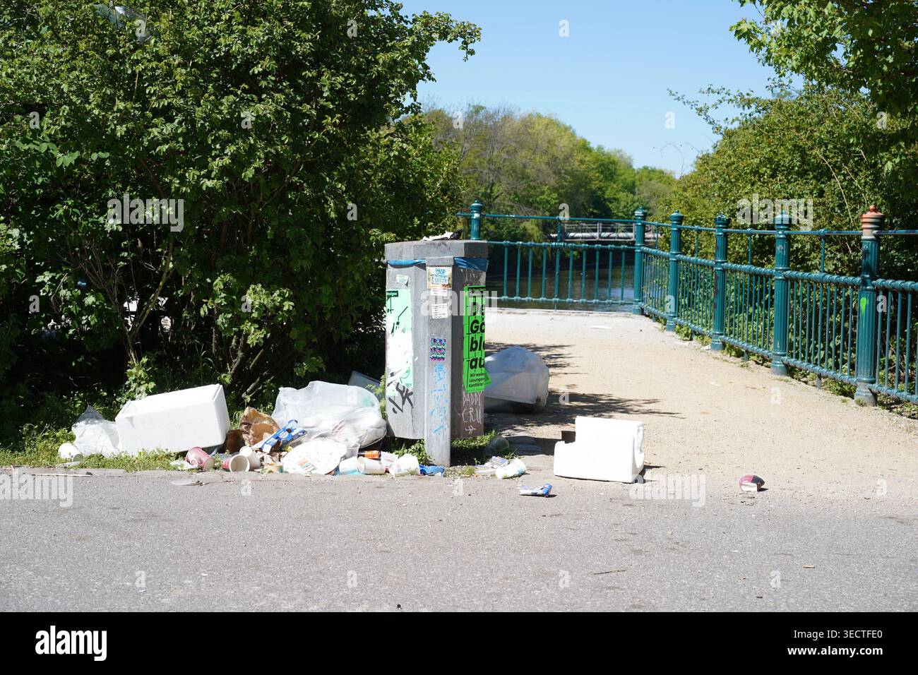 Berlin, Allemagne - 2 mai 2026 : poubelle débordante et déchets éparpillés sur le sentier du mur de Berlin (Mauerweg) à Lohmühlenbrücke dans l'Alt-Treptow. Banque D'Images