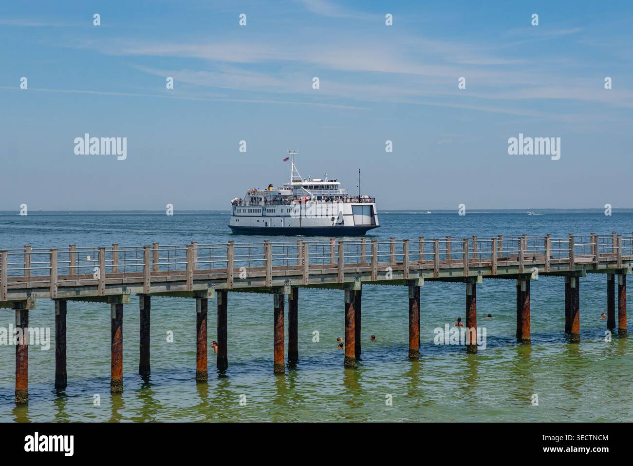 Oak Bluffs, Martha's Vineyard, ma, États-Unis-3 juillet 2025 : le ferry arrive au terminal de l'île et les gens nagent à la plage regardant le ferry. Banque D'Images