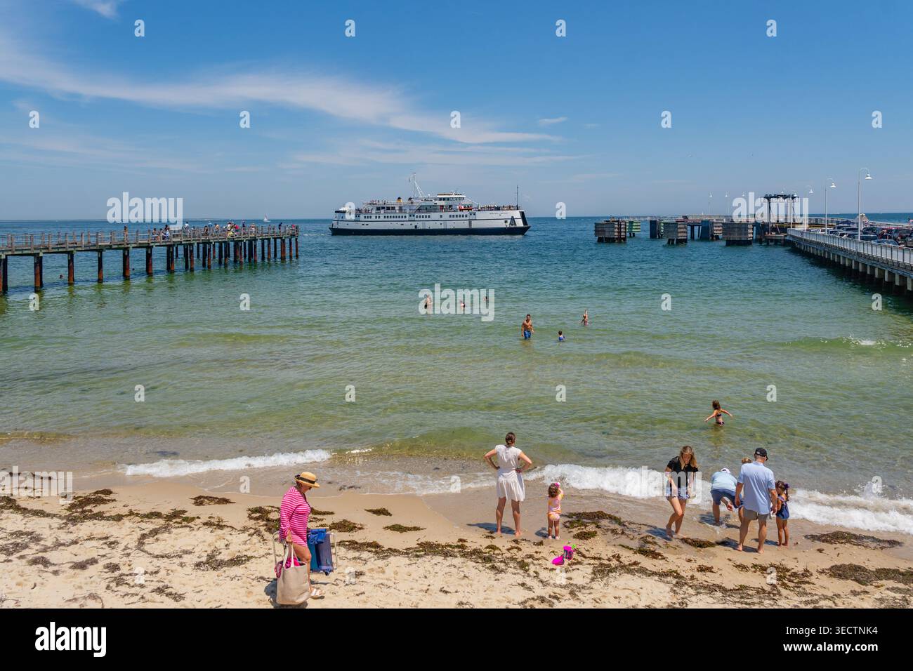 Oak Bluffs, Martha's Vineyard, ma, États-Unis-3 juillet 2025 : le ferry arrive au terminal de l'île et les gens nagent à la plage regardant le ferry. Banque D'Images