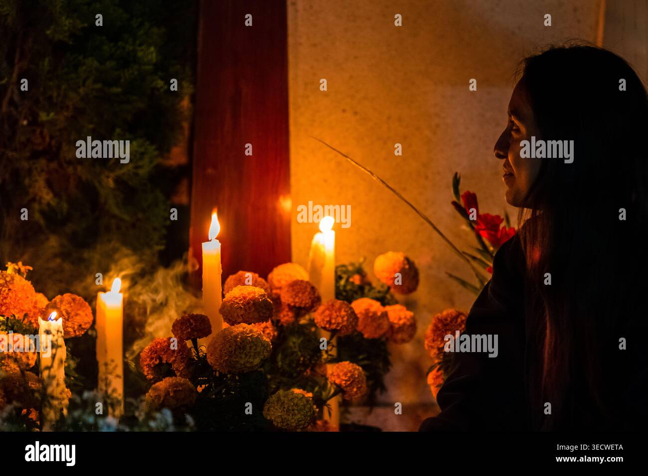 Une mexicaine visite la tombe de ses parents lors de la célébration du jour des morts à San Andrés Mixquic, au Mexique. Banque D'Images