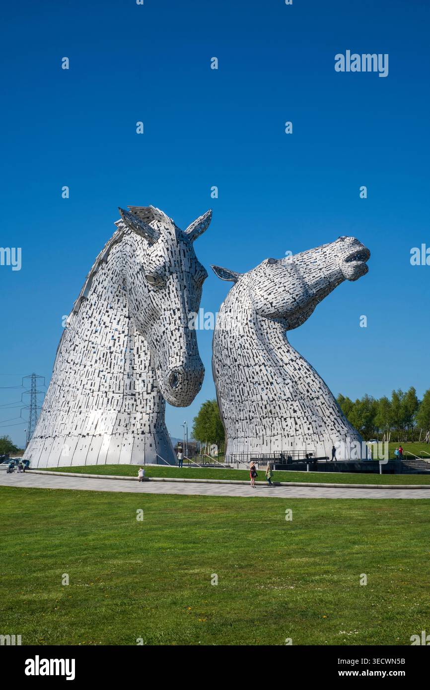 Les Kelpies à Falkirk, en Écosse, sous un ciel bleu ensoleillé. Les sculptures emblématiques de tête de cheval sont un monument écossais majeur de l'artiste Andy Scott Banque D'Images
