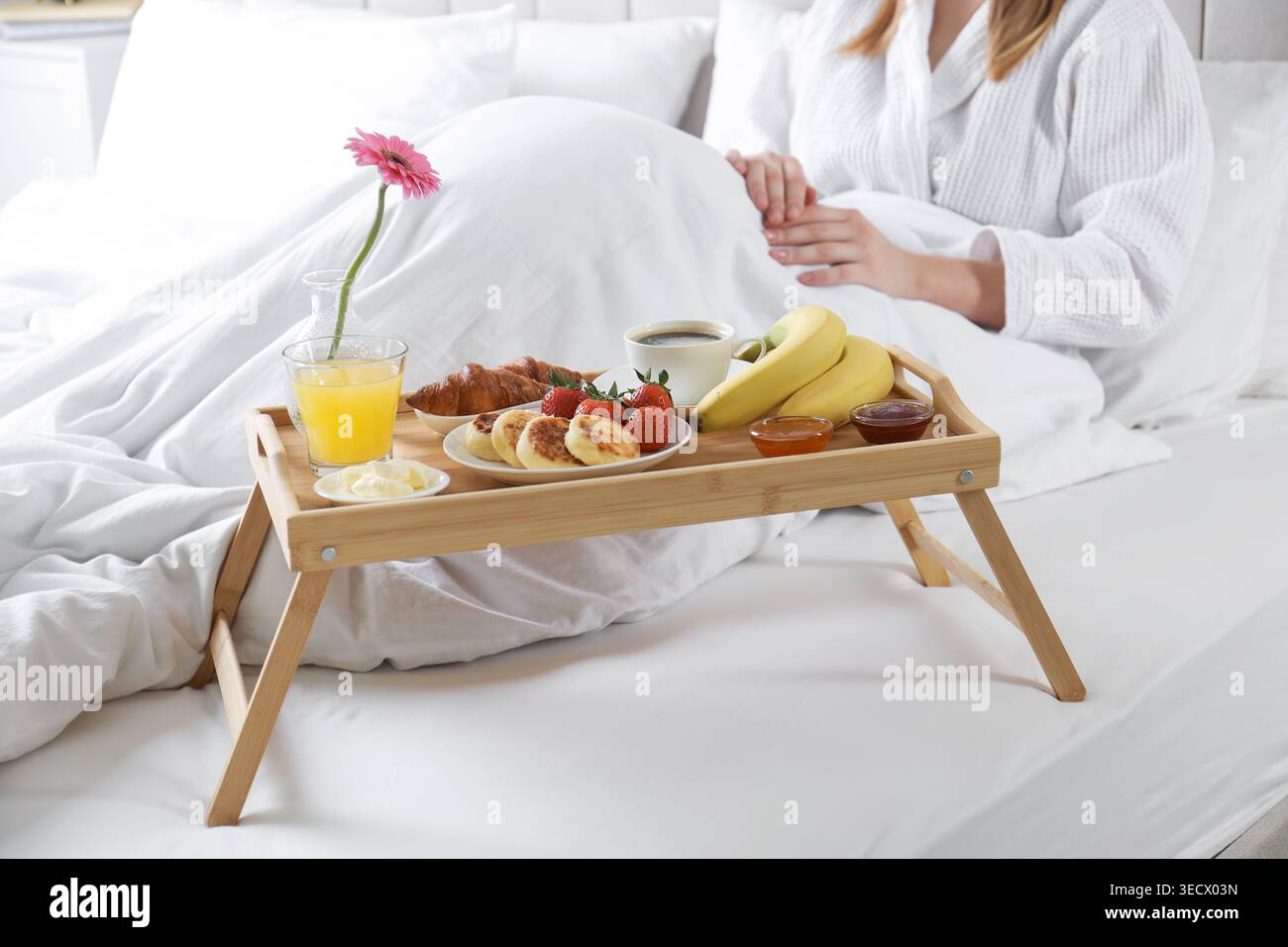 Femme mangeant délicieux petit déjeuner au lit à l'intérieur, gros plan Banque D'Images