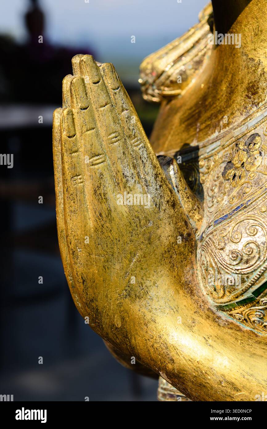 Gros plan des mains d'une statue de Bouddha dorée avec des paumes pressées ensemble dans une expression de paix et de vénération pour Dieu. Banque D'Images