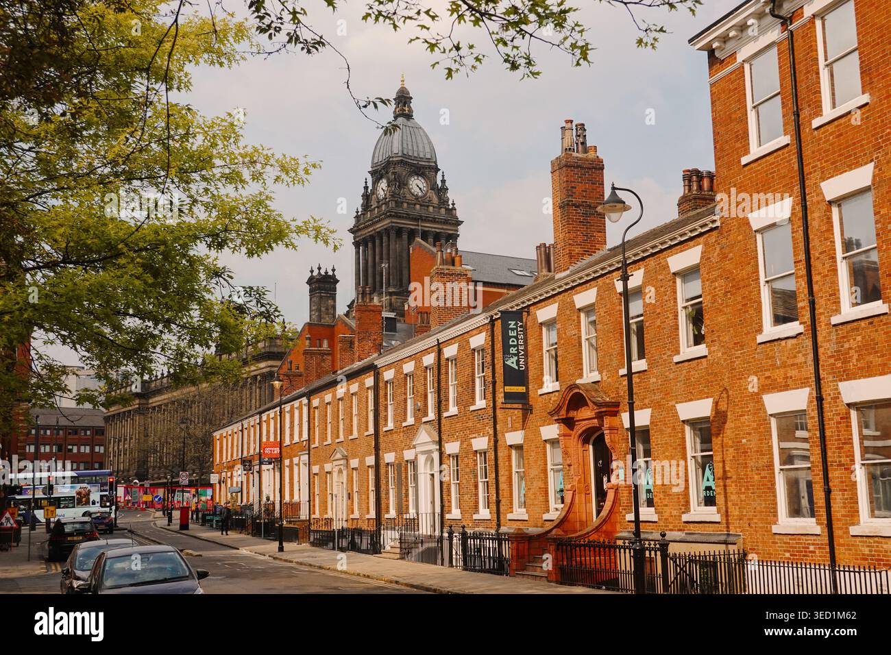 Vue de la tour de l'horloge de l'hôtel de ville de Leeds derrière des bâtiments historiques en briques rouges sur Park Lane, Leeds, West Yorkshire, Angleterre, Royaume-Uni Banque D'Images