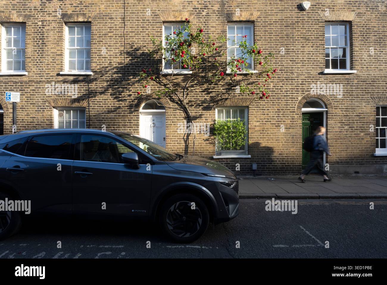 Une personne passe devant une voiture dans une rue de Londres Roupell Street Banque D'Images