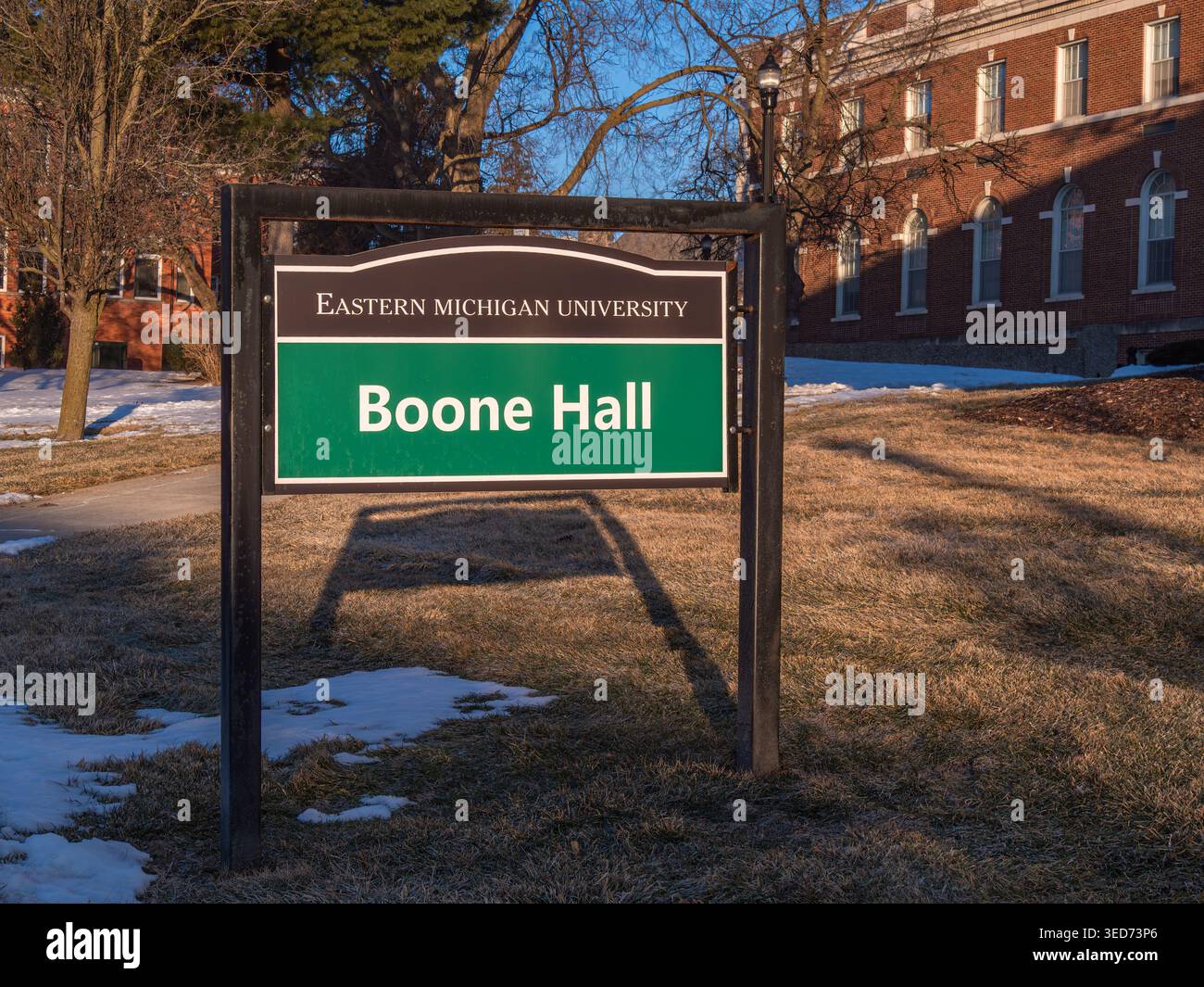 Ypsilanti, États-Unis - 12 février 2026 : panneau de campus lisant l'université de l'est du michigan boone hall sur la pelouse d'hiver avec bâtiment académique en brique, arbres, bleu Banque D'Images