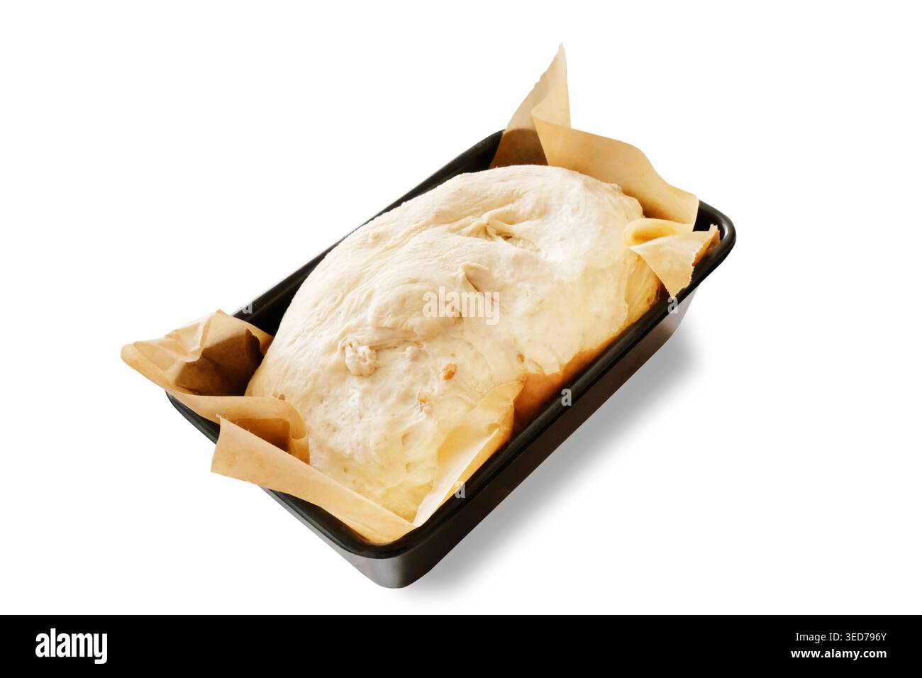 Pâte à pain maison prouvant dans un moule à pain recouvert de papier parchemin prêt à cuire au four. Découpez l'image sur un fond blanc. Banque D'Images