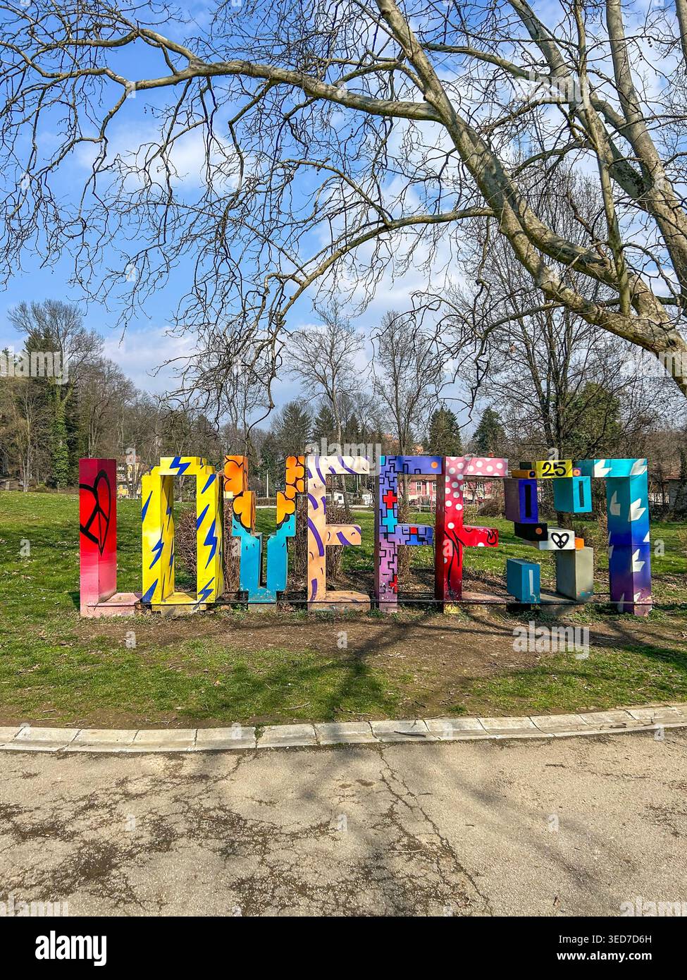 Signe vibrant Love Fest dans le parc Vrnjacka Banja, Serbie, entouré d'arbres et de la nature sous un ciel bleu vif. - Image de stock capturée avec un smartphone