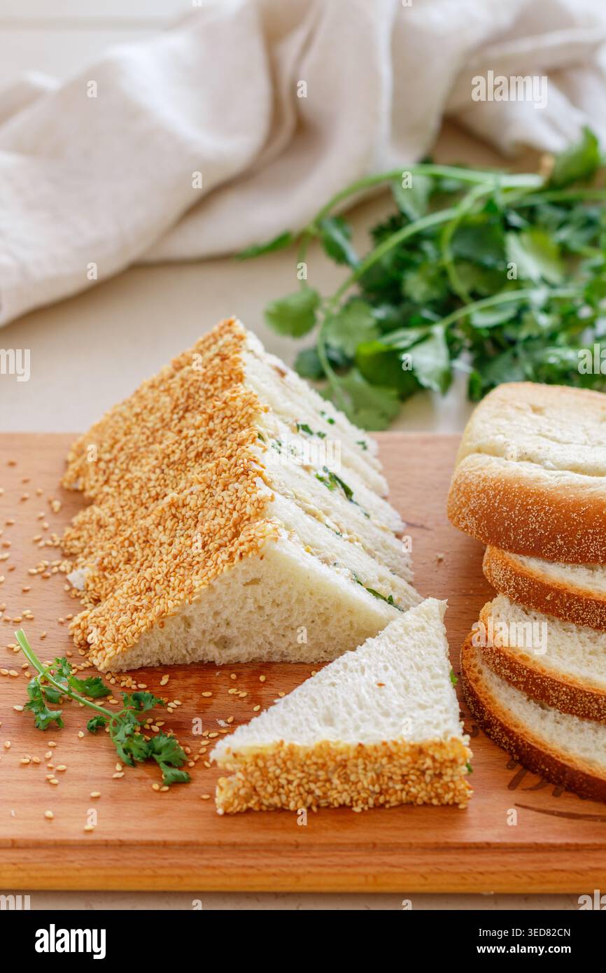 Sandwichs au thé. Mini-snack traditionnel de pain blanc avec beurre et salade de poulet, œufs, concombre, herbes et mayonnaise aux graines de sésame. Sélectionnez Banque D'Images
