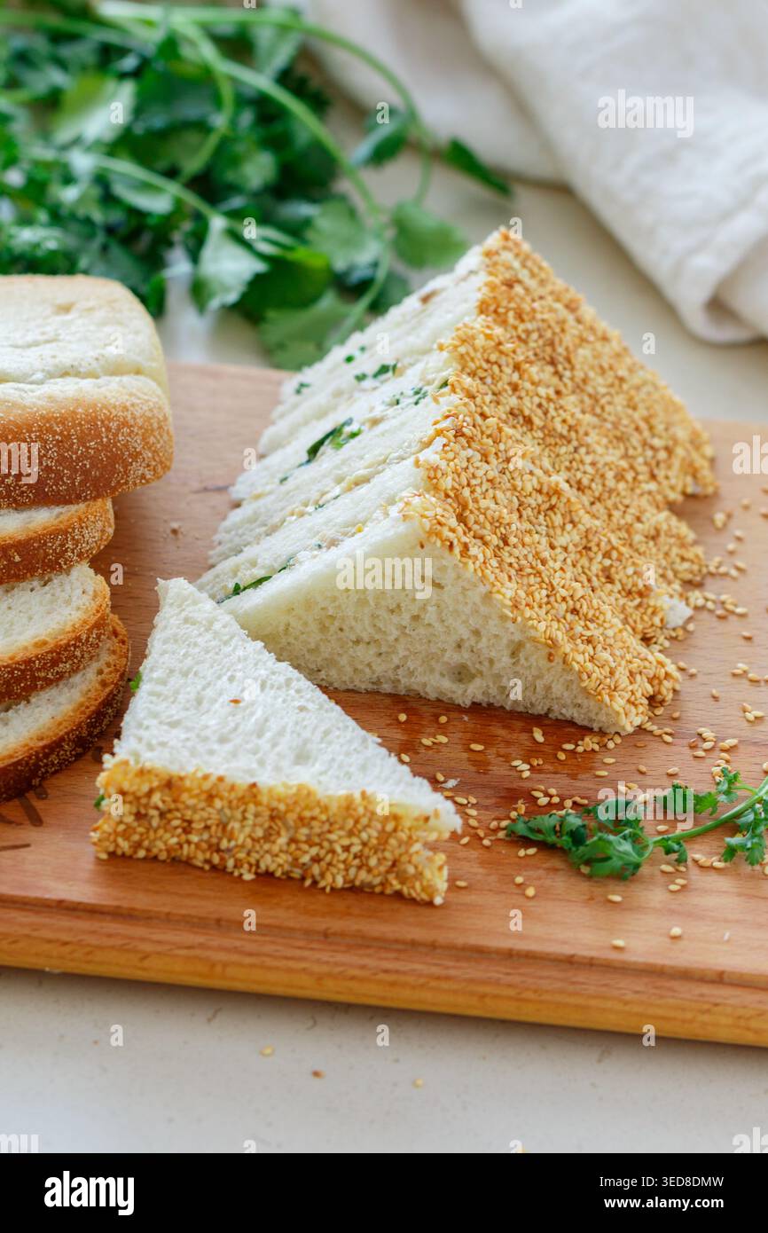 Sandwichs au thé. Mini-snack traditionnel de pain blanc avec beurre et salade de poulet, œufs, concombre, herbes et mayonnaise aux graines de sésame. Sélectionnez Banque D'Images