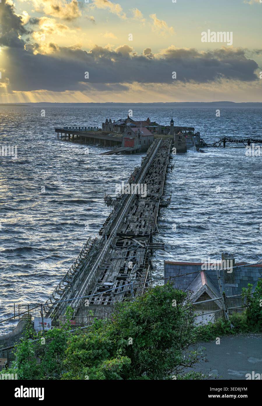 Jetée de Birnbeck abandonnée au coucher du soleil avec mer agitée et ciel dramatique, Weston-super-Mare, Somerset, Angleterre, Royaume-Uni Banque D'Images