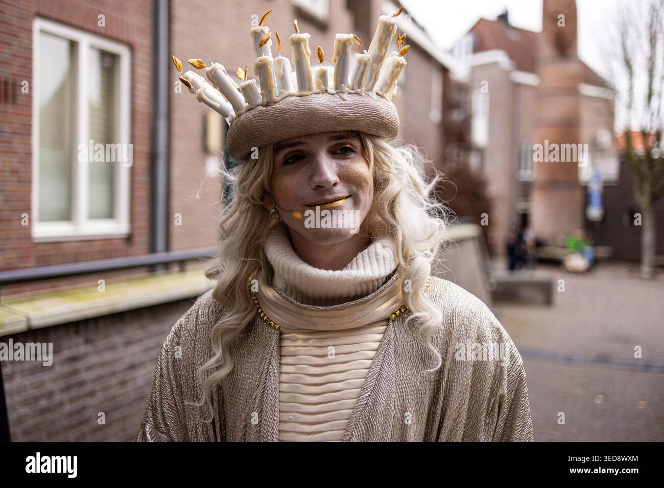 Deventer, Overijssel, pays-Bas - 14.12.2025, personne en costume mystique avec couronne de bougie et maquillage en or lors d'un festival de rue. Caractère artistique Banque D'Images