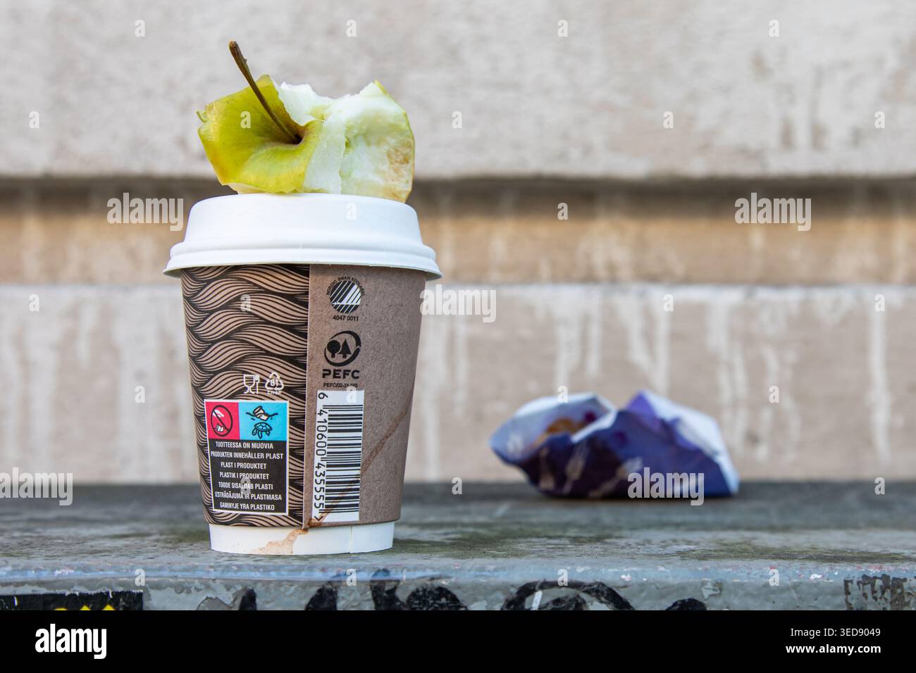Noyau de pomme, tasse à café jetable et emballage de collation laissés sur une armoire utilitaire à Helsinki, en Finlande Banque D'Images