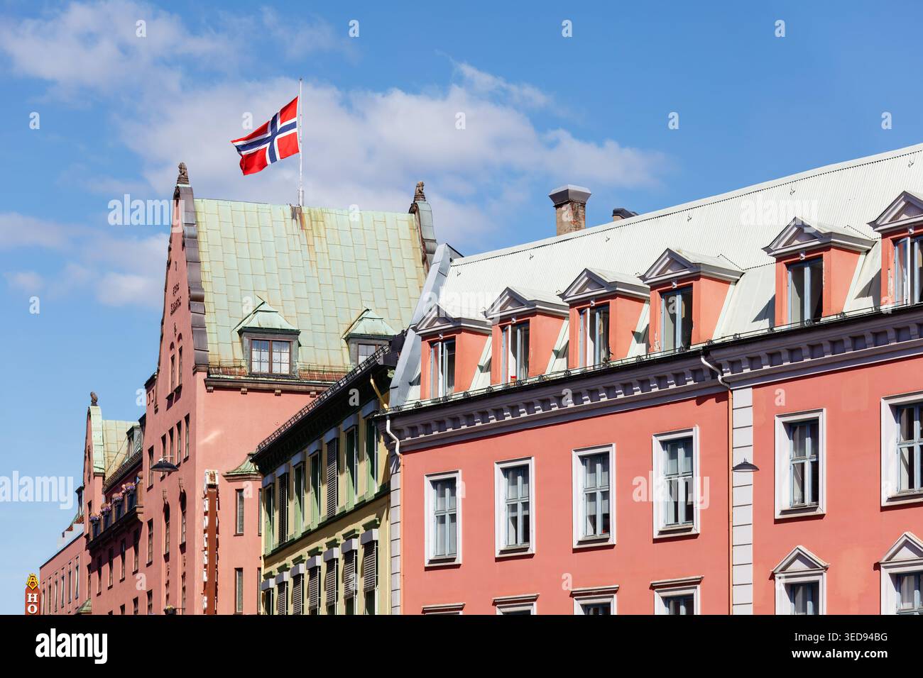 Oslo, 17 mai 2025 : drapeau norvégien flottant au-dessus des bâtiments historiques colorés dans le centre-ville - charme de l'architecture traditionnelle et l'esprit patriotique Banque D'Images