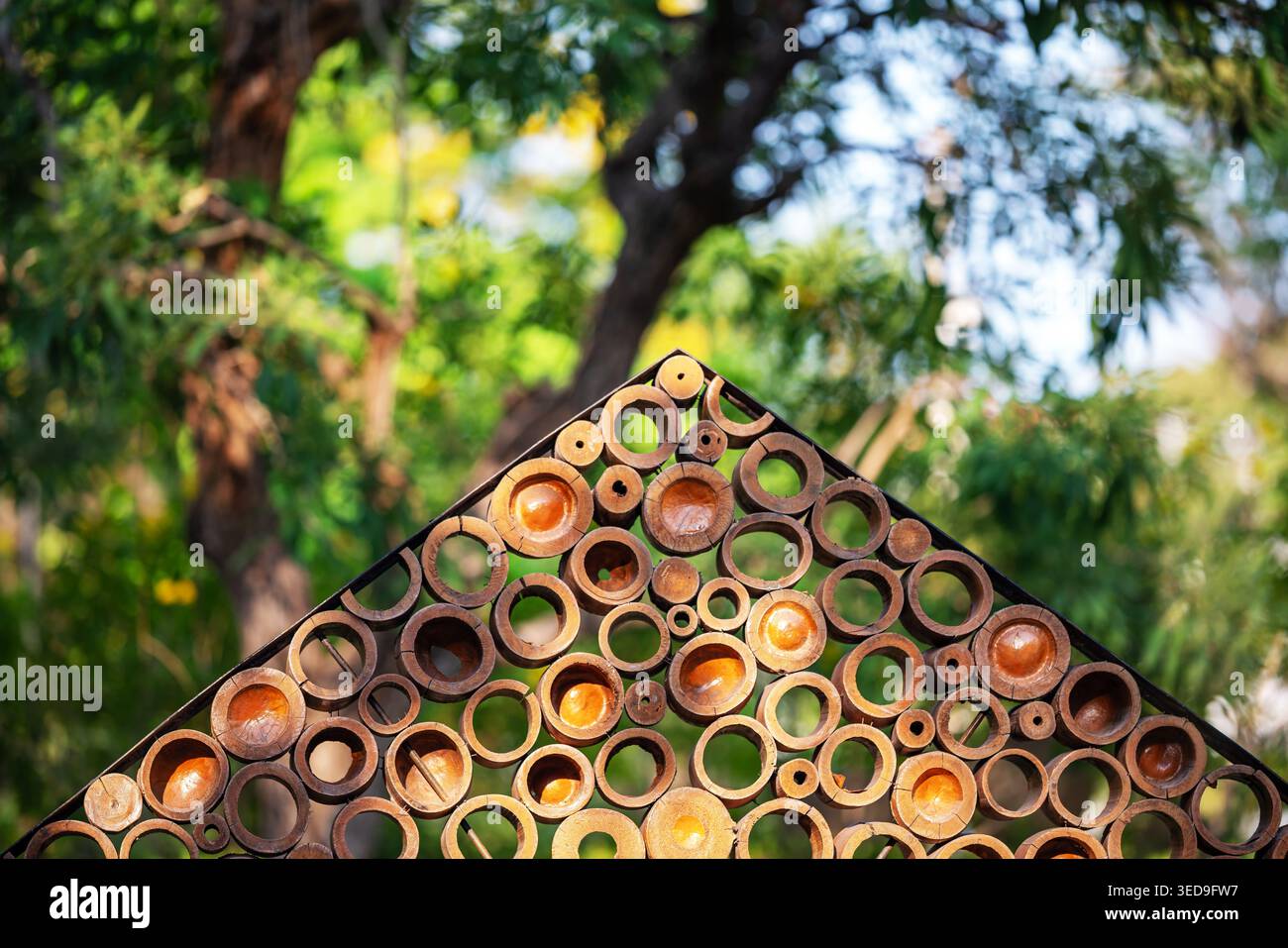 Cette image présente une structure extérieure unique avec des éléments circulaires en bois. L'interaction de la lumière et de l'ombre crée une scène vibrante, Banque D'Images