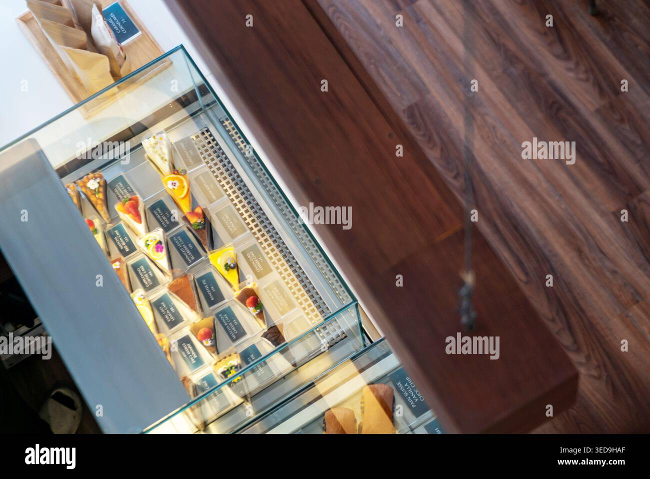 Un intérieur de magasin de détail moderne avec une vitrine en verre rempli de desserts colorés, chocolats, pâtisseries et bonbons, offrant un fo invitant Banque D'Images