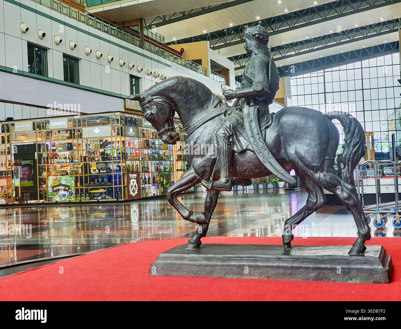 Une grande statue équestre en bronze d'un guerrier ou roi historique armé portant un turban et une couronne se dresse de manière proéminente sur un tapis rouge à l'intérieur d'un Banque D'Images