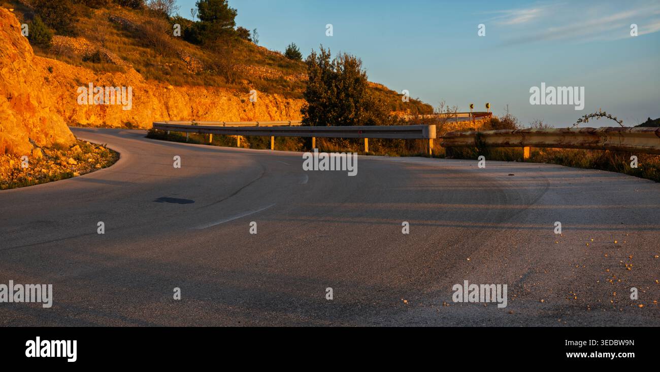 Une route sinueuse spectaculaire sur l'île de Hvar, baignée par la lumière du soleil levant Banque D'Images