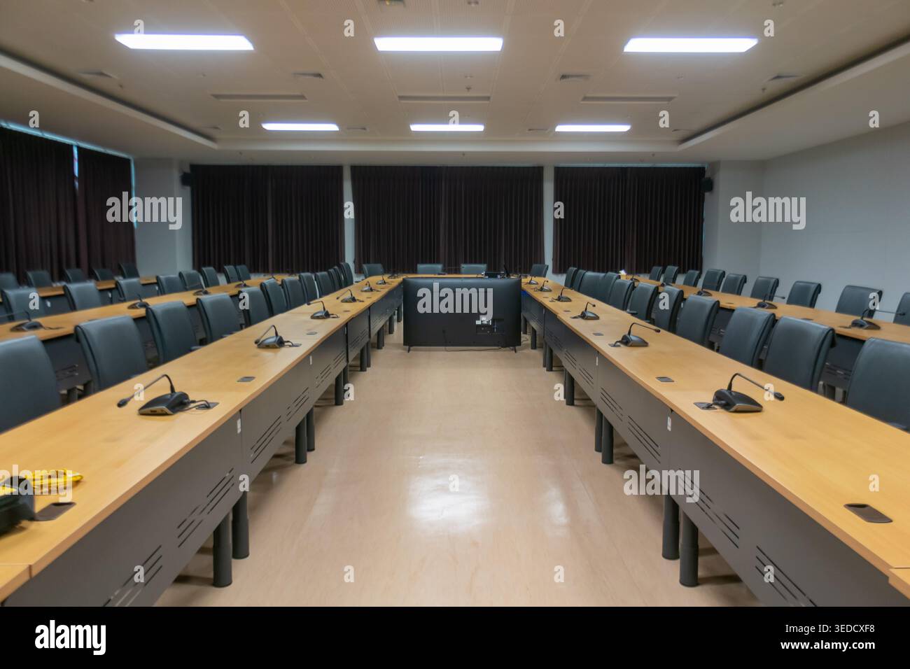 Salle de conférence spacieuse et moderne avec de longues tables et des sièges confortables. Idéal pour les réunions, les présentations et les sessions collaboratives. Banque D'Images