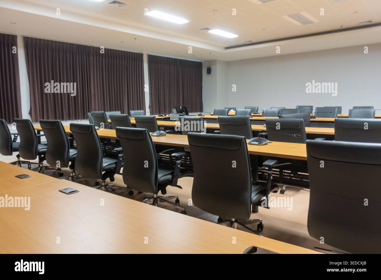 Salle de conférence moderne avec aménagement spacieux avec mobilier élégant, configuration vide et éclairage subtil, parfaite pour les réunions d'entreprise et les présentati Banque D'Images