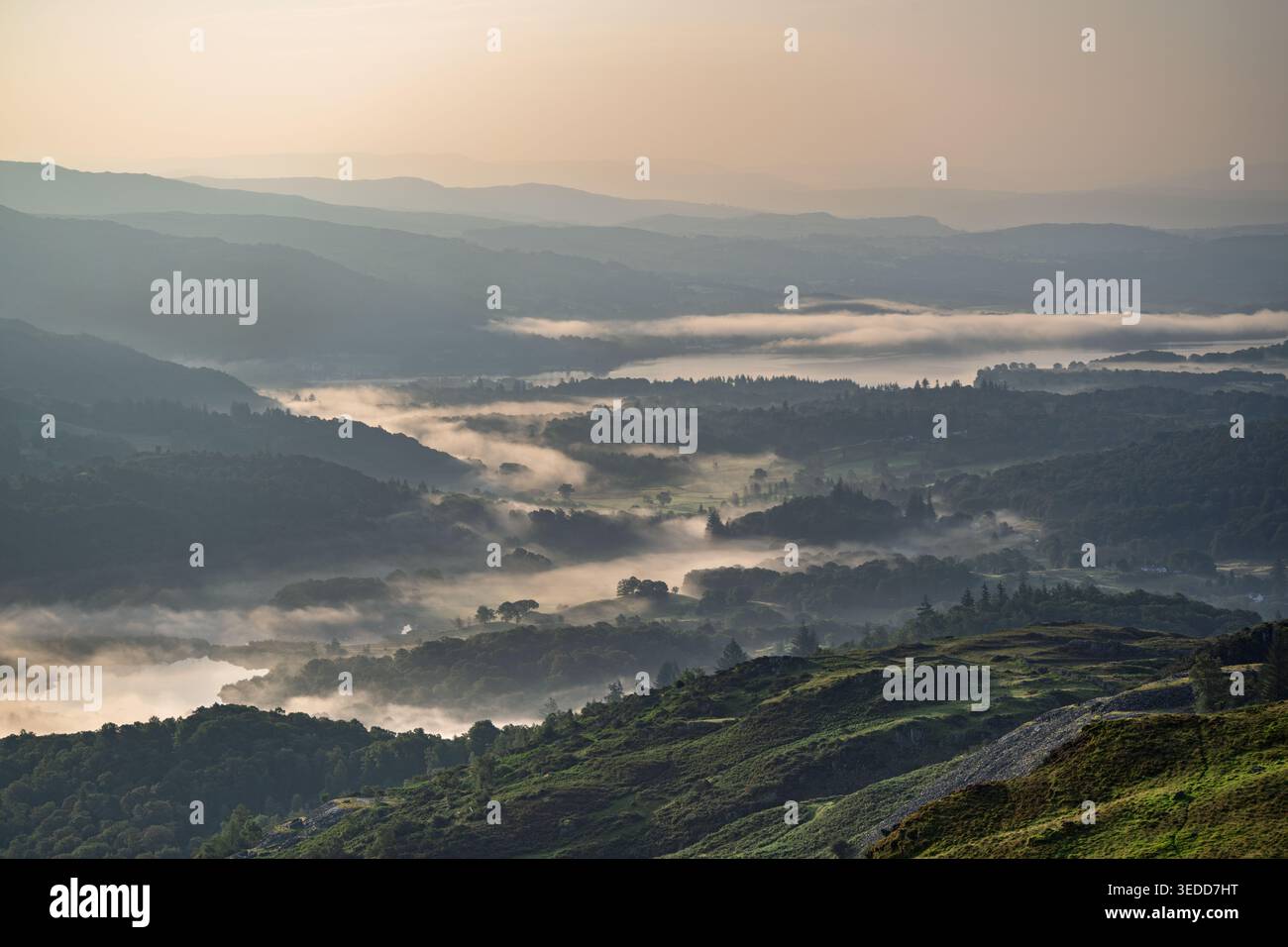 Vue aérienne du brouillard tôt le matin s'accumulant dans la vallée de Langdale vue depuis les montagnes du Lake District, Royaume-Uni. Banque D'Images