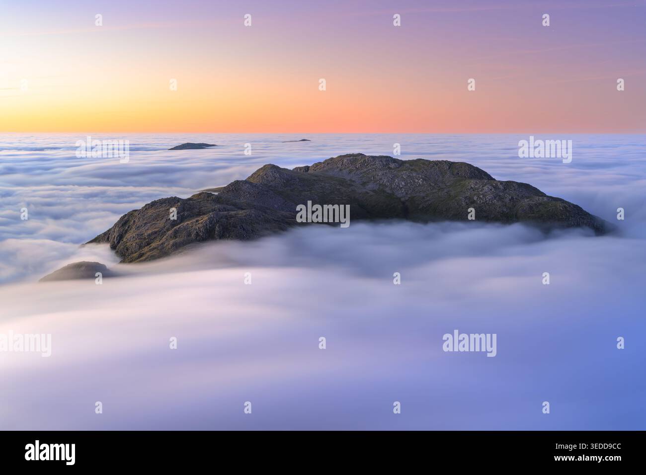 Les sommets de montagne au-dessus d'une mer de brouillard lors d'une inversion de nuages par un matin calme. Crinkle Crags, Lake District, Royaume-Uni. Banque D'Images