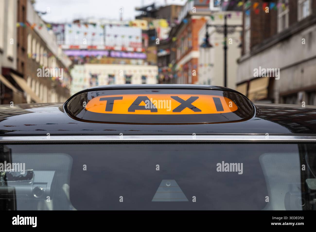 Gros plan d'un panneau de taxi jaune sur un taxi noir dans la ville Banque D'Images