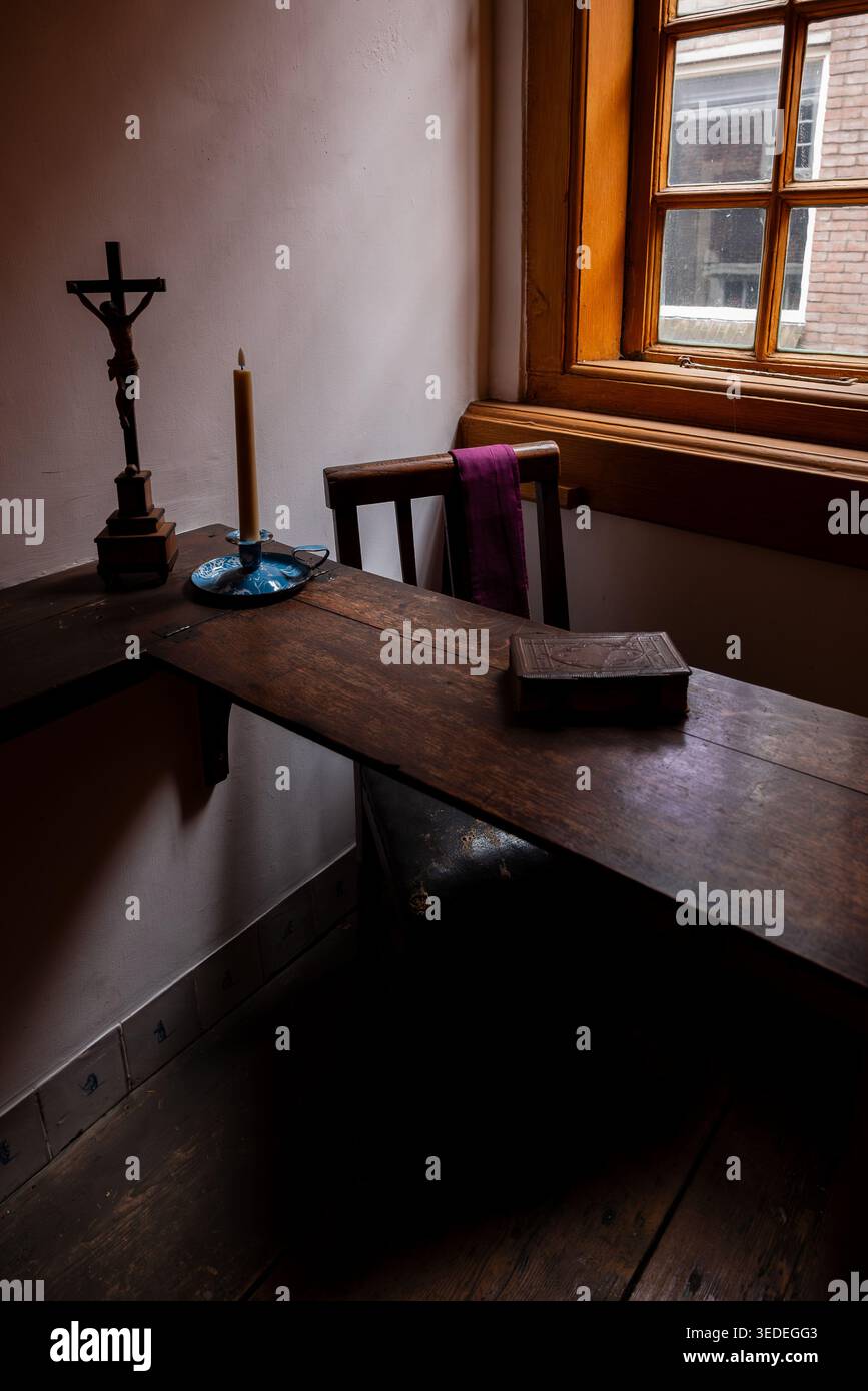 Amsterdam, pays-Bas 16 février 2026 Bureau historique avec un crucifix et une bougie dans le musée caché de l'église d'Amsterdam. Authentique DUT du XVIIe siècle Banque D'Images