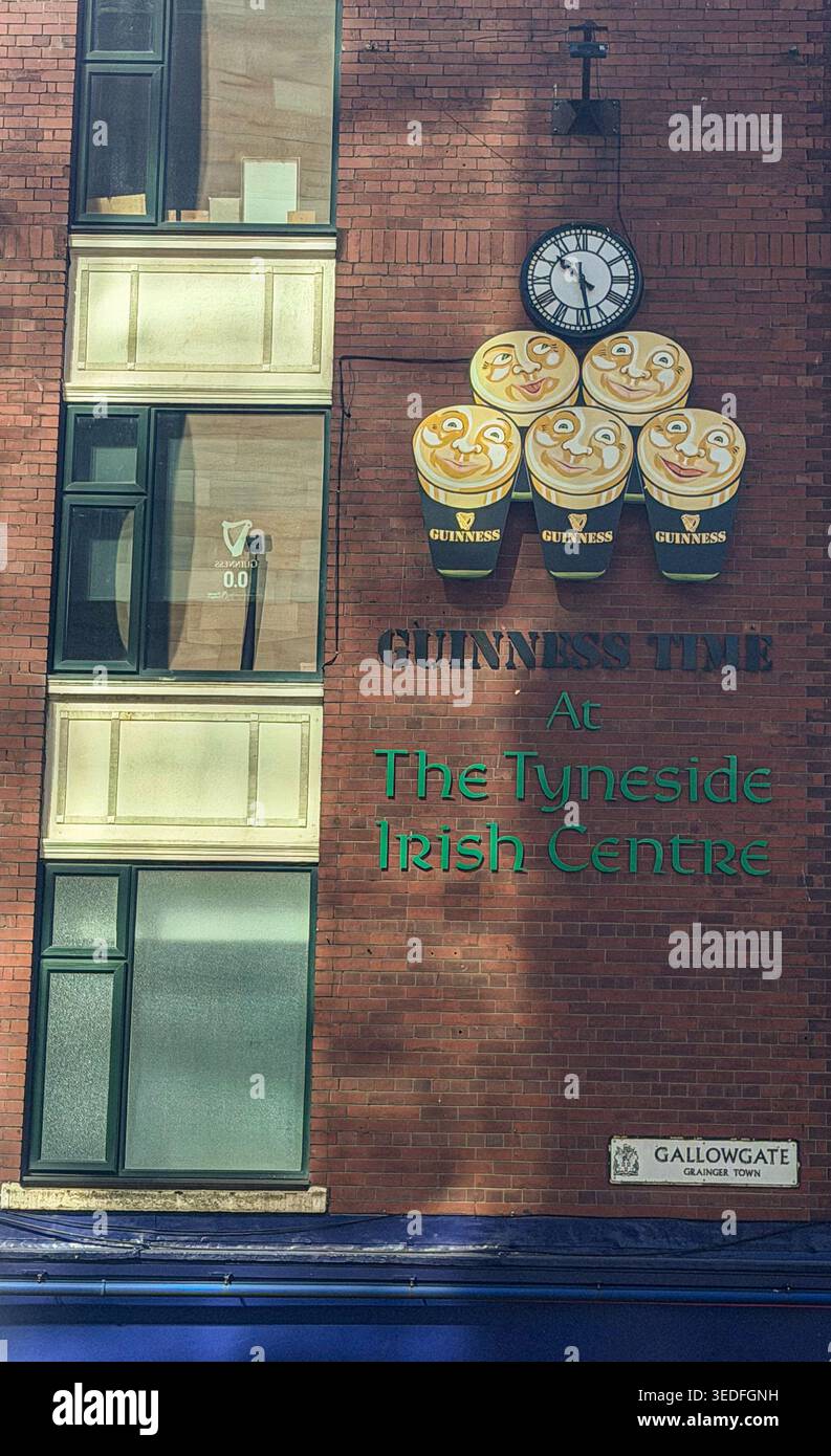 Mur de briques du Tyneside Irish Centre à Newcastle avec un panneau horaire Guinness classique et une horloge - Image de stock capturée avec un smartphone